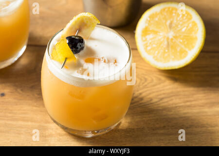 Dolci fatti in casa Amarreto Whiskey Sour cocktail con una ciliegia Foto Stock