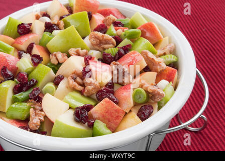 Una sana Waldorf insalata di frutta fatta con mele Granny Smith e le mele gala, noci, mirtilli, cipolle, sedano in una salsa vinaigrette. Foto Stock