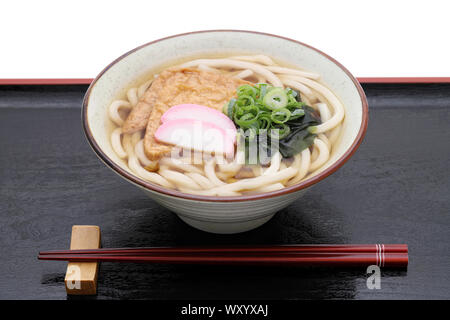 Kitune giapponese udon tagliatelle in un vaso di ceramica sul vassoio in legno Foto Stock