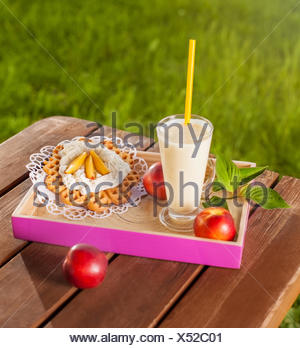 Waffle e frullato sul tavolo di legno nel giardino. Debica, Polonia Foto Stock