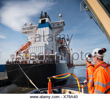 Lavoratori sul rimorchiatore affacciato sulla nave Foto Stock