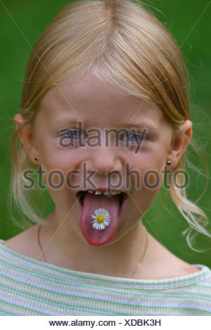 Daisy comune, prato daisy, inglese daisy (Bellis perennis), la ragazza con un fiore sulla sua lingua, Germania